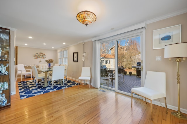 dining room featuring hardwood / wood-style flooring, plenty of natural light, and ornamental molding