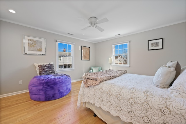 bedroom with baseboards, visible vents, ceiling fan, ornamental molding, and wood finished floors