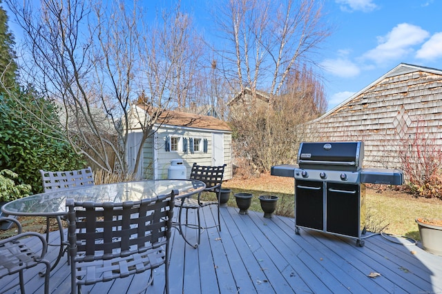 deck featuring a grill, an outdoor structure, and outdoor dining space