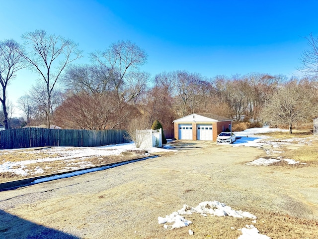 view of yard with a garage, fence, and an outdoor structure