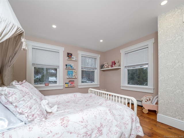 bedroom featuring multiple windows, baseboards, wood finished floors, and recessed lighting