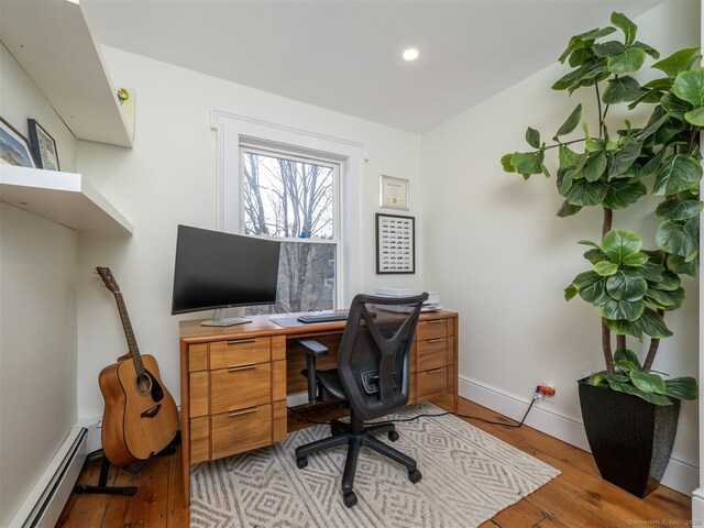 office space with light wood-type flooring, baseboards, a baseboard heating unit, and recessed lighting