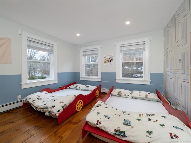 bedroom featuring baseboard heating, wood finished floors, and recessed lighting