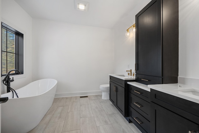 1600 S Main St, Cheshire, CT 06410 - bathroom with a freestanding tub, baseboards, vanity, and toilet