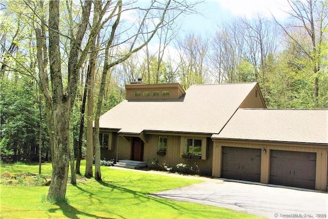 view of front of property with a garage, driveway, and a front lawn