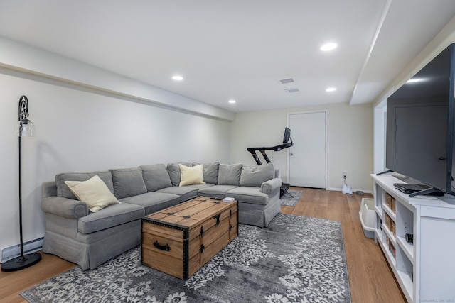 living room featuring a baseboard heating unit, recessed lighting, baseboards, and light wood-style floors