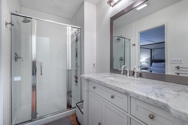 bathroom featuring a stall shower, ensuite bathroom, and vanity