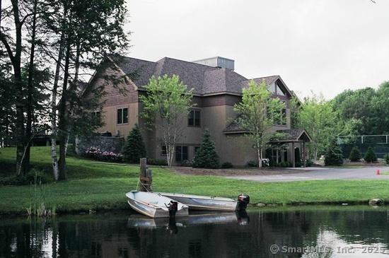 back of property featuring a yard, a water view, and stucco siding