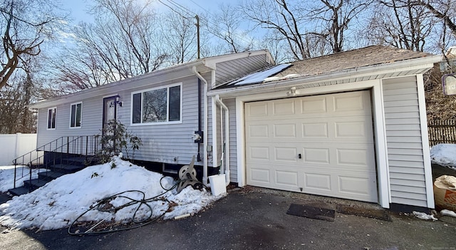 view of front of home with a garage, driveway, and fence