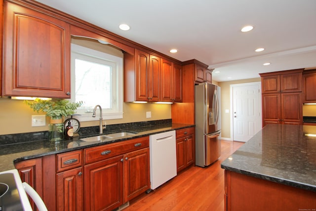 kitchen with a sink, recessed lighting, stainless steel fridge, light wood-style floors, and dishwasher