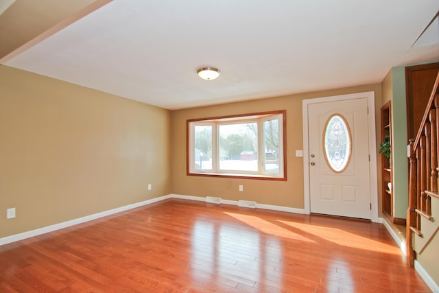 entryway featuring visible vents, stairway, baseboards, and light wood-style floors