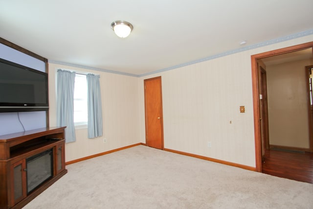 unfurnished living room featuring baseboards, carpet, and wallpapered walls