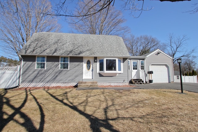 view of front of house featuring fence, a shingled roof, entry steps, a garage, and aphalt driveway