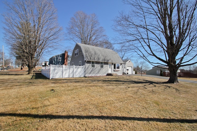 view of side of property with a gambrel roof, a lawn, and fence