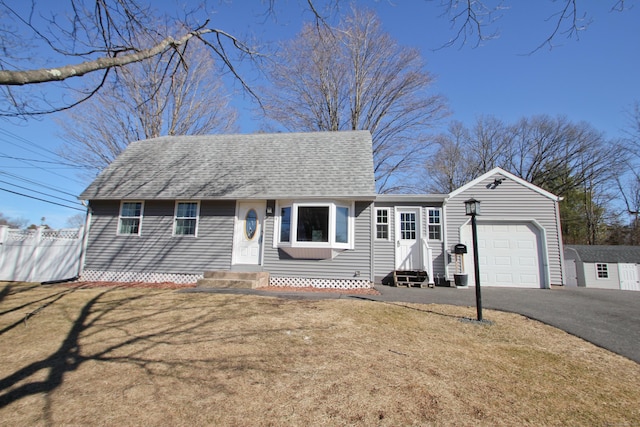 view of front of property with a shingled roof, fence, aphalt driveway, entry steps, and a garage