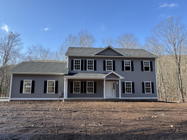 colonial-style house featuring a shingled roof