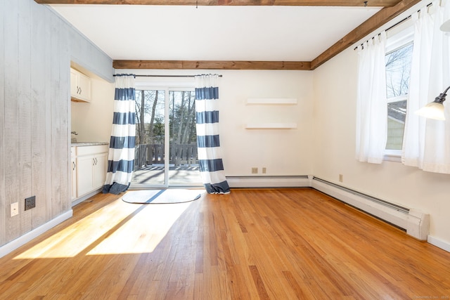 unfurnished room with a baseboard heating unit, light wood-type flooring, baseboards, and a baseboard radiator