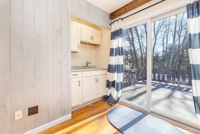 doorway to outside with a sink and light wood-style flooring