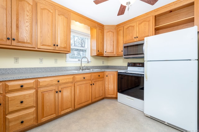 kitchen featuring a sink, electric stove, light countertops, freestanding refrigerator, and stainless steel microwave