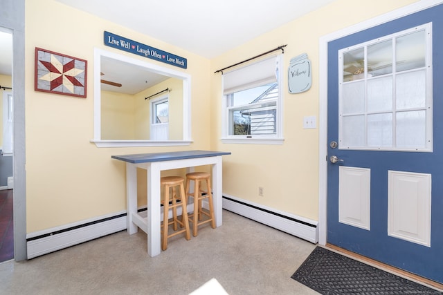 carpeted foyer featuring a baseboard heating unit