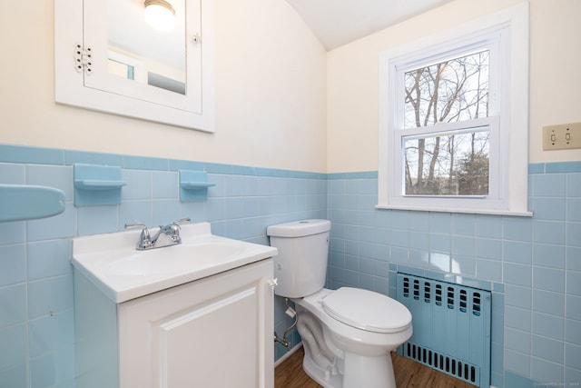 bathroom featuring radiator, wainscoting, toilet, and vanity