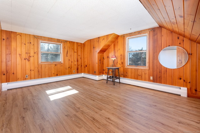 bonus room featuring lofted ceiling, wood walls, and wood finished floors