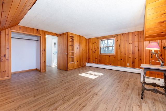 bonus room featuring wooden walls, baseboards, wood finished floors, vaulted ceiling, and baseboard heating