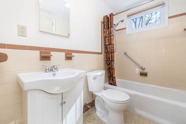 bathroom featuring tile walls, toilet, shower / bath combo, wainscoting, and vanity