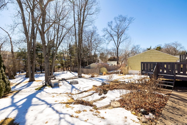 yard covered in snow with an outdoor fire pit and a deck