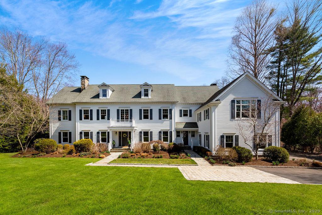 view of front facade featuring a chimney and a front lawn