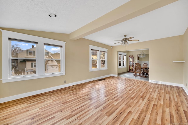 spare room with baseboards, plenty of natural light, and light wood-style floors