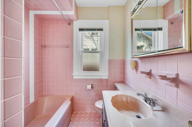 full bath featuring toilet, tile walls, a wealth of natural light, and shower / bathing tub combination