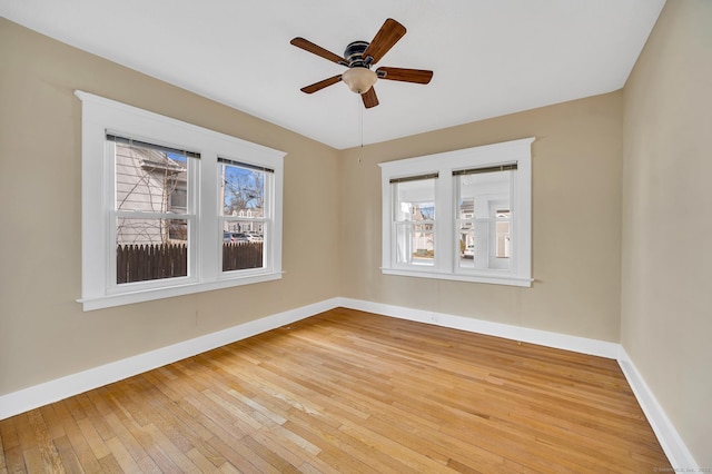 unfurnished room with hardwood / wood-style flooring, plenty of natural light, baseboards, and ceiling fan