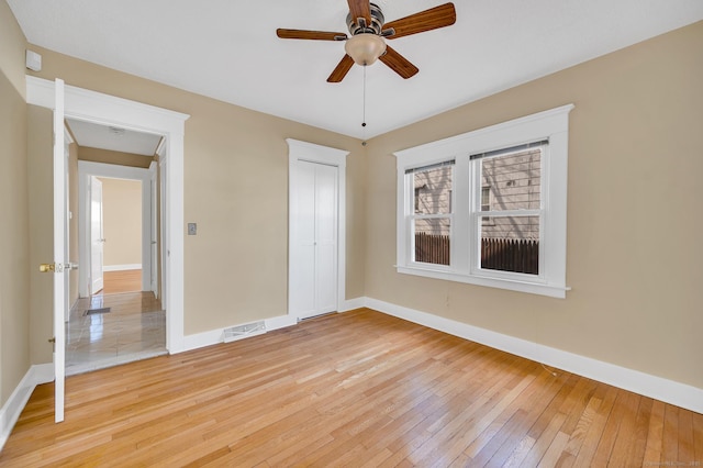 unfurnished bedroom featuring light wood finished floors, a closet, and baseboards