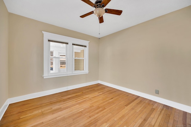 spare room featuring light wood-type flooring, ceiling fan, and baseboards