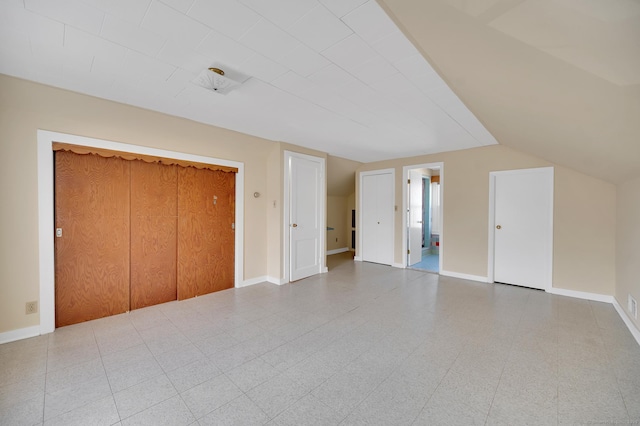 unfurnished bedroom with baseboards and vaulted ceiling