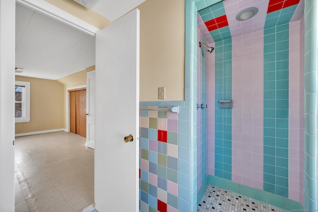 full bath with tiled shower, wainscoting, and tile patterned floors