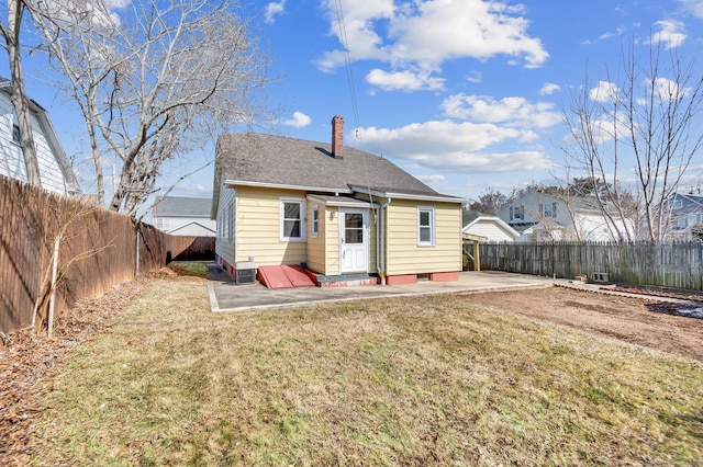 back of house with a patio, a fenced backyard, a shingled roof, a lawn, and a chimney