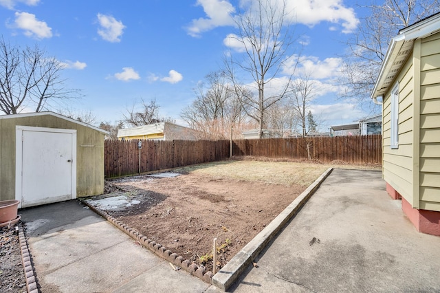 view of yard with a fenced backyard, a shed, a patio, and an outbuilding