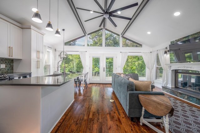 kitchen featuring dark countertops, dark wood-style floors, open floor plan, white cabinetry, and a sink