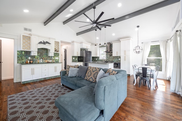 living area featuring dark wood-style flooring, visible vents, high vaulted ceiling, beamed ceiling, and ceiling fan with notable chandelier