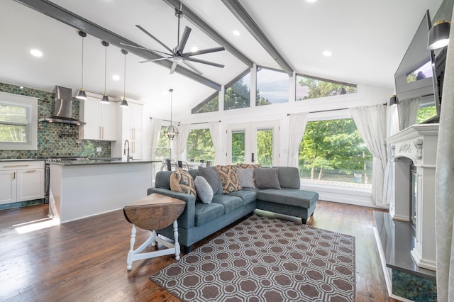 living room with dark wood-type flooring, beamed ceiling, a fireplace, and a wealth of natural light