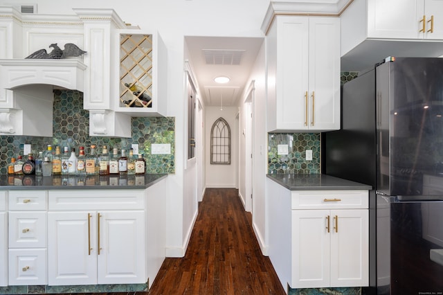 kitchen featuring visible vents, dark wood-type flooring, freestanding refrigerator, and tasteful backsplash