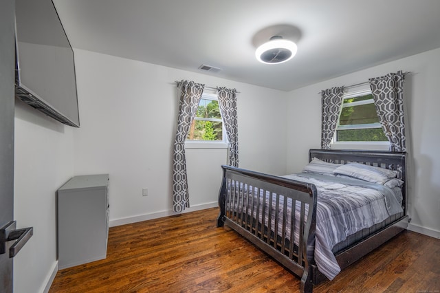 bedroom with baseboards, visible vents, and dark wood-style flooring