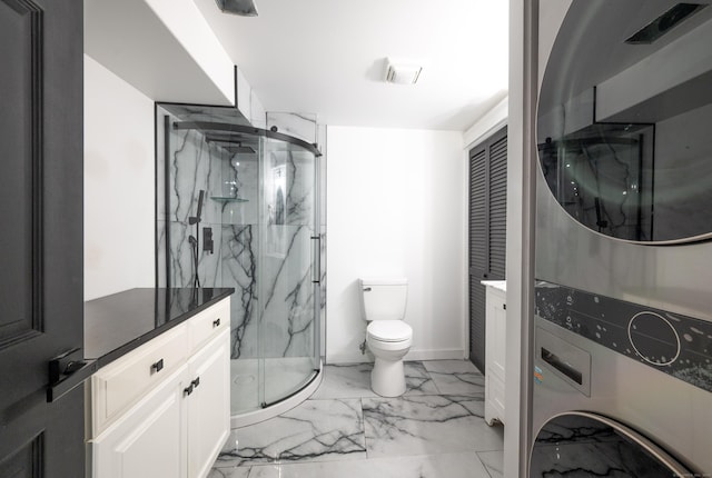 bathroom featuring toilet, stacked washer / drying machine, marble finish floor, a closet, and a marble finish shower