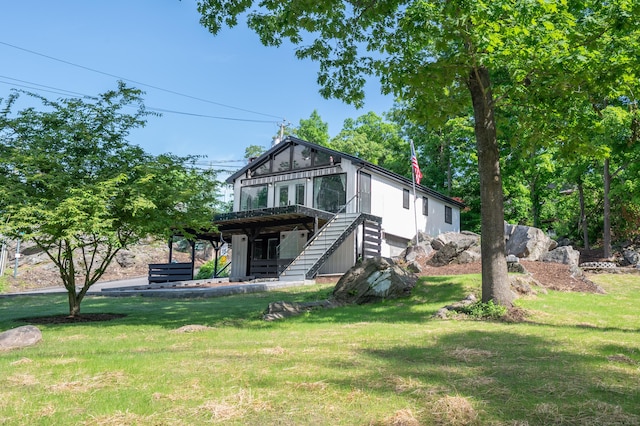 view of front of home featuring stairs and a front lawn