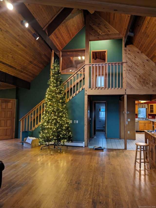 unfurnished living room featuring beam ceiling, wood ceiling, wood finished floors, high vaulted ceiling, and stairs