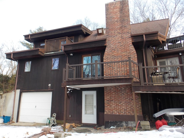 exterior space featuring a chimney, brick siding, a balcony, and roof with shingles