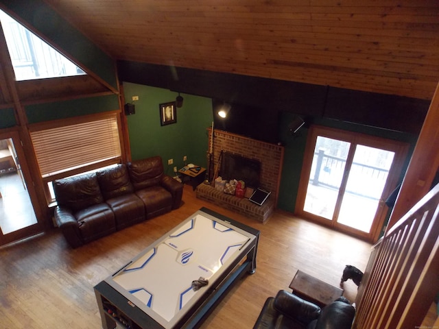 living area featuring lofted ceiling, plenty of natural light, and wood finished floors