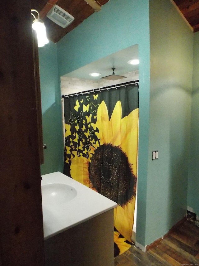 bathroom with wood finished floors, a sink, and visible vents